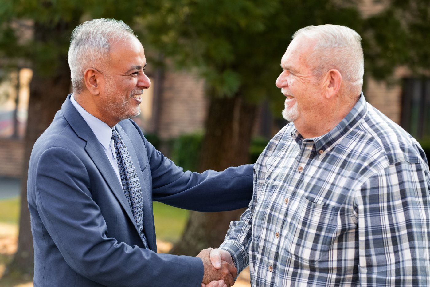 Dr. Saud Anwar shaking hands with an older resident