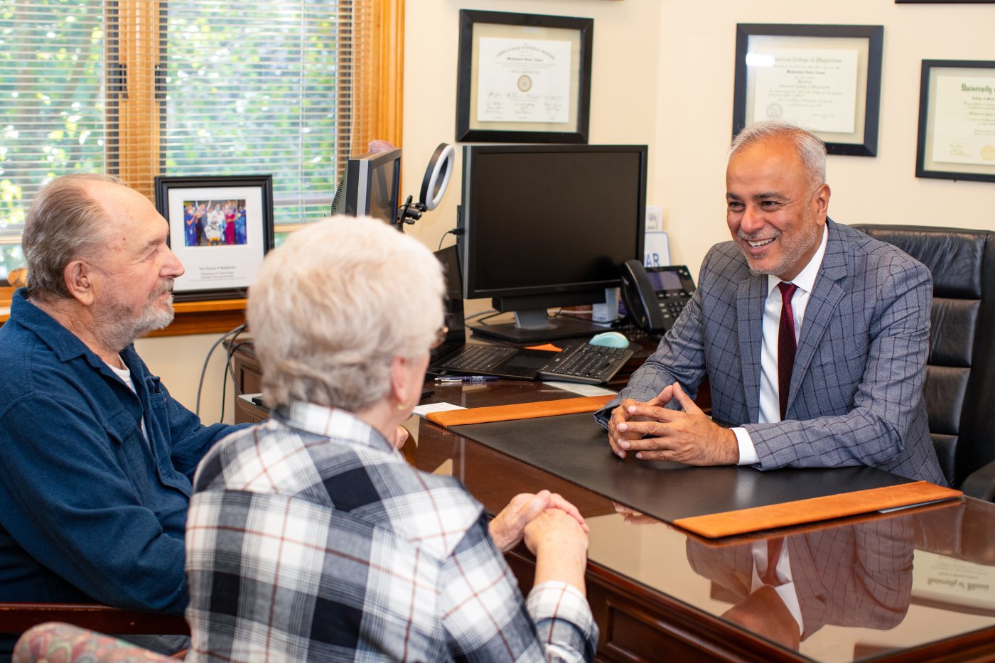 Dr. Saud Anwar meeting with a senior constituent at a desk