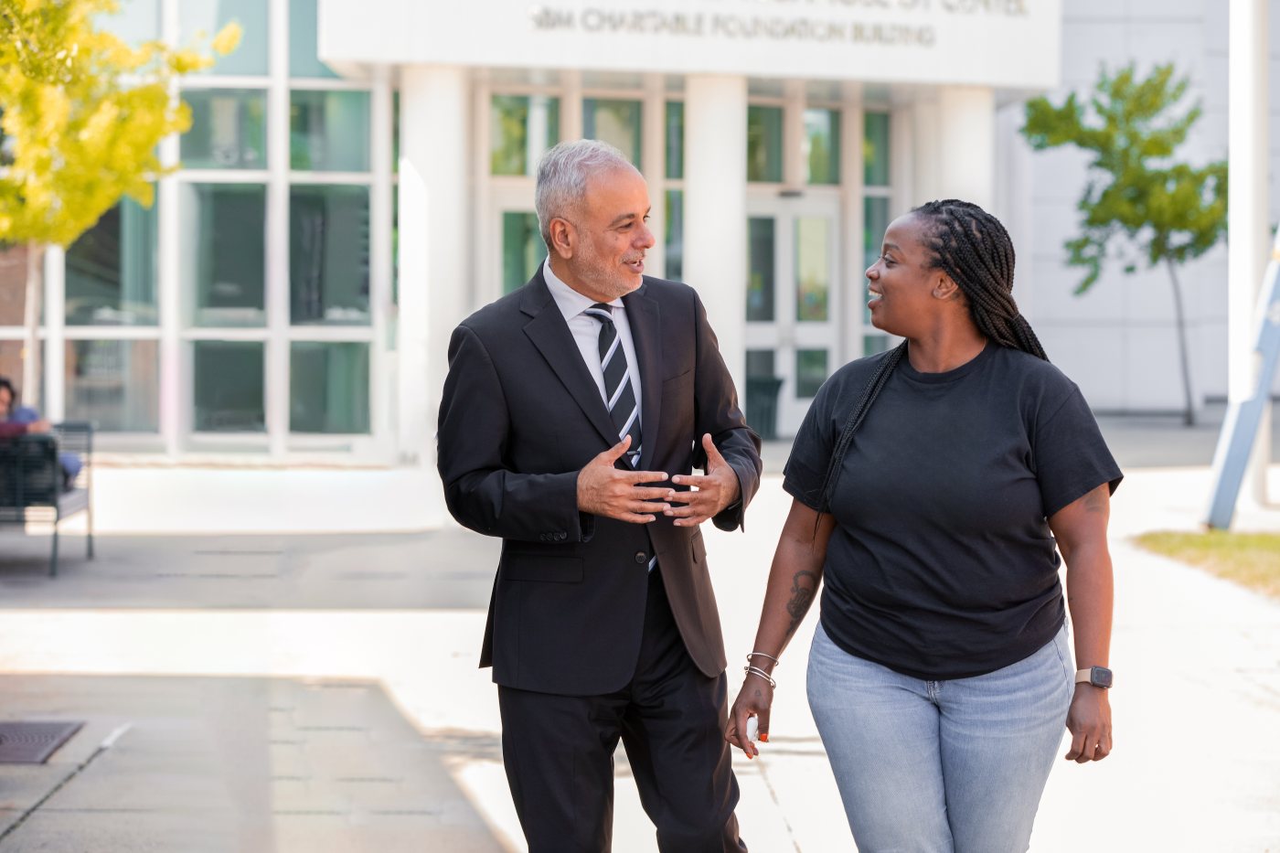 Dr. Saud Anwar walking and talking with a community member