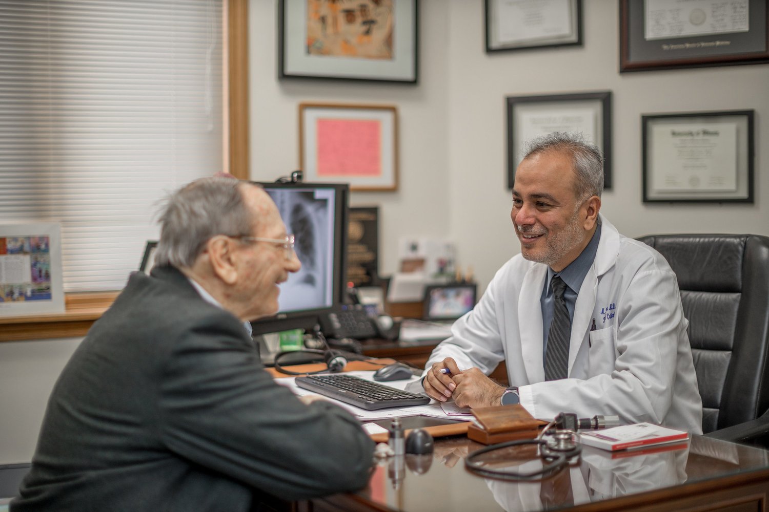 Dr. Saud Anwar, in his white coat, with a patient